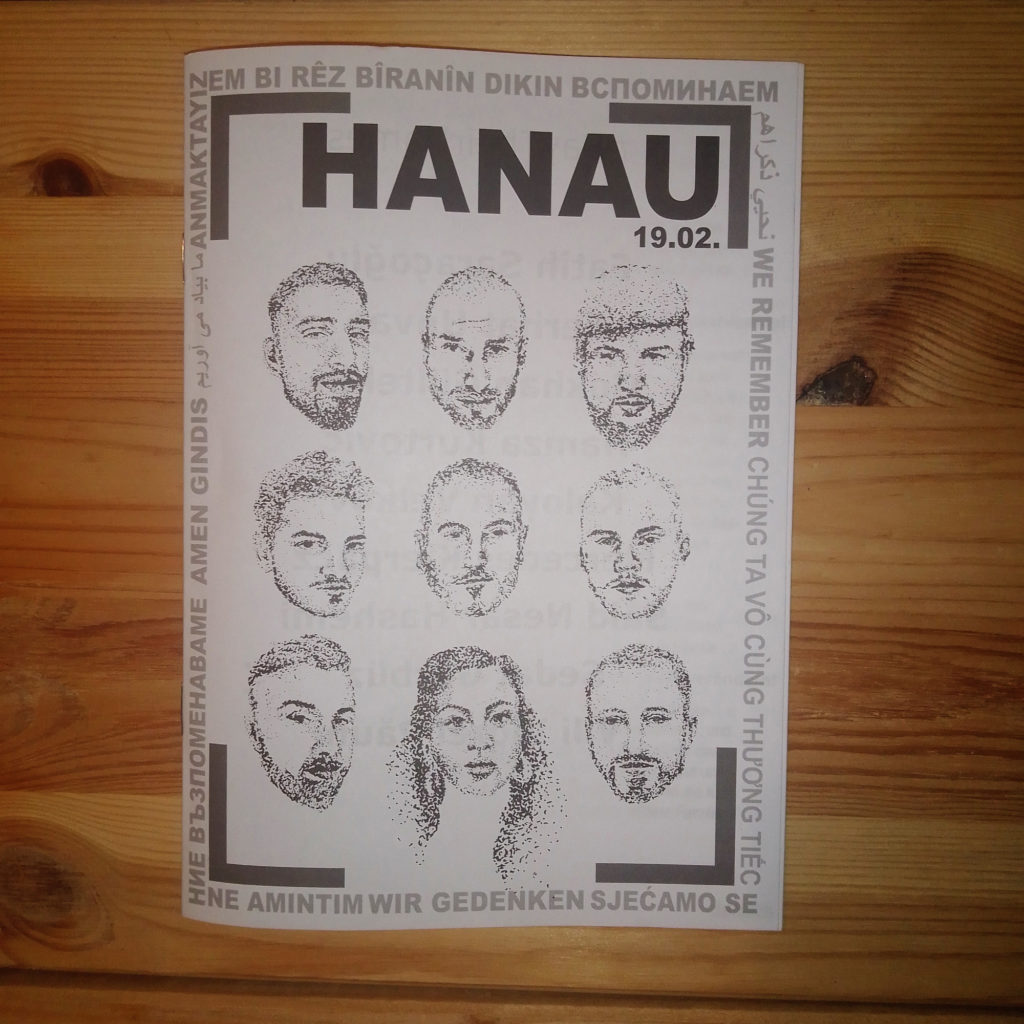 Gedenkheft mit Titel HANAU 19.02. Gesichter von 9 Opfer*innen sind gezeichnet, umrandet von "wir gedenken" in 12 Sprachen