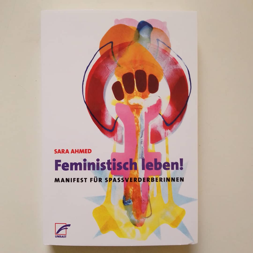 Cover von Feministisch leben! von Sara Ahmed. Zeichen für Frauenkampftag, gemalt mit rosa, dunkelrot, orange.