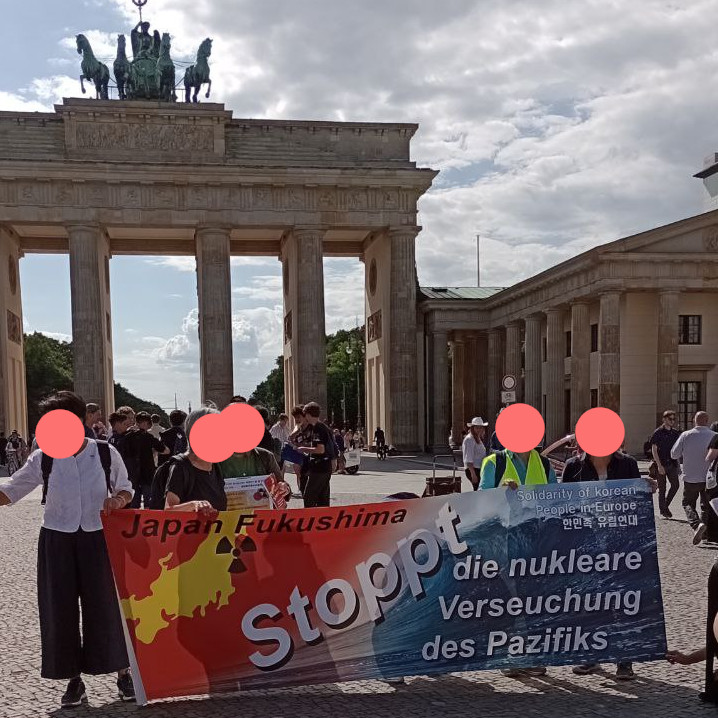Menschen halten den Banner, Stoppt die nukleare Verseuchung des Pazifiks, vor dem Brandenburger Tor, Berlin