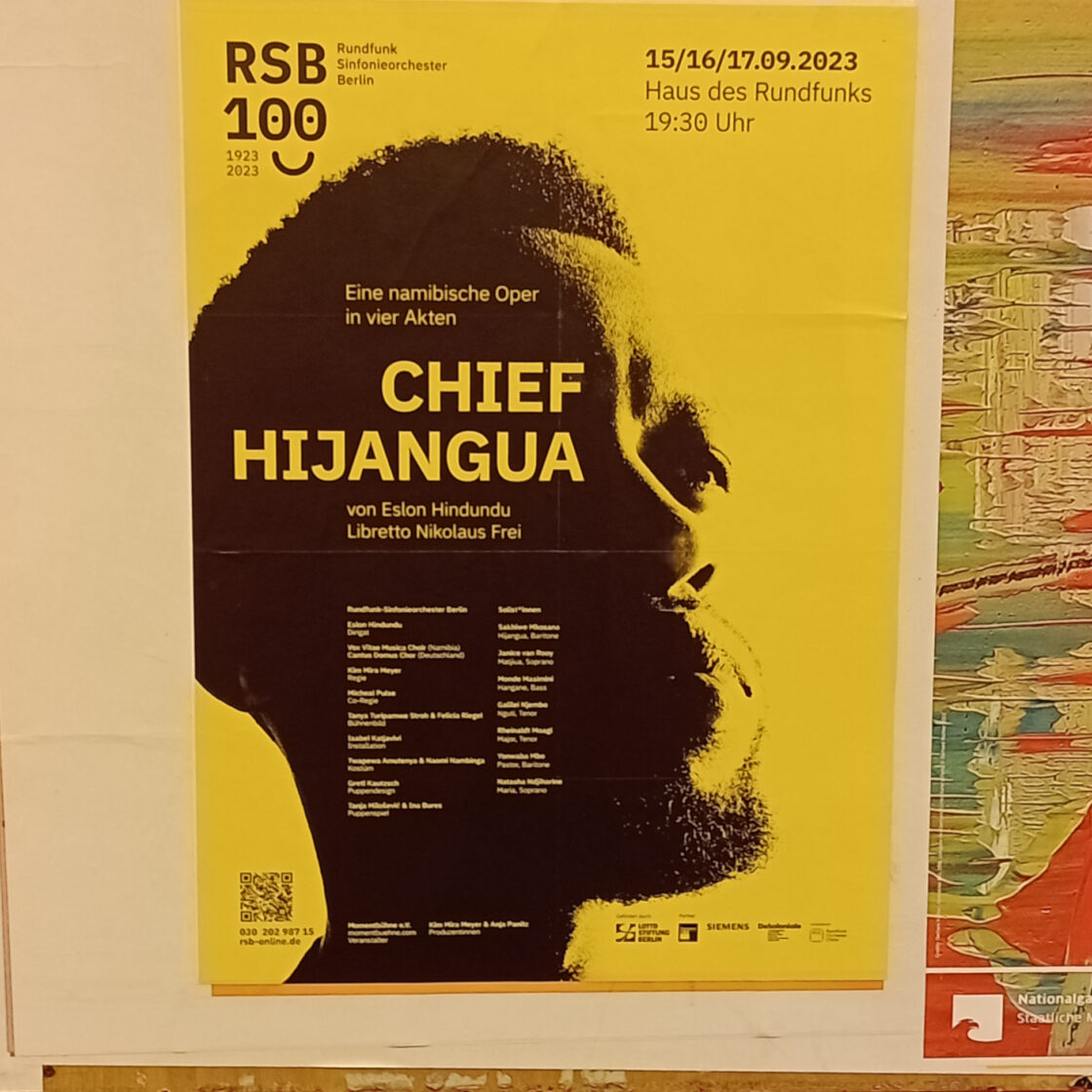 Poster von Chief Hijangua geklebt an einer Wand. Gelbe Hintergrund mit einem Foto von Sakhiwe Mkosana, der Hijangua spielt.