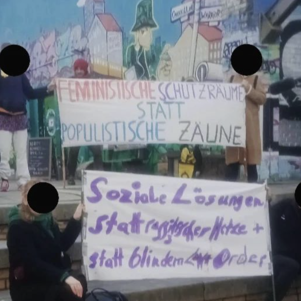 Zwei Banner vor der bunten Wand von Pamukkale, Görlitzer Park. "Feministische Schutzräume statt populistische Zäune" "Soziale Lösungen statt rassistischer Hetze + stat t Low and Order"